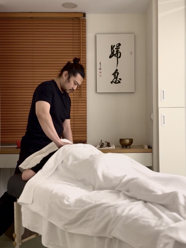 承恩在工作室裡，站在覆著白布的床邊
